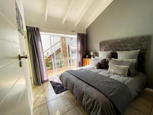 1 dormitorio con cama y ventana grande en Luxurious Central Knysna Home en Knysna
