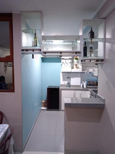 Apartamentos ARCEMIR في اياكوتشو: مطبخ مع دواليب بيضاء ومغسلة