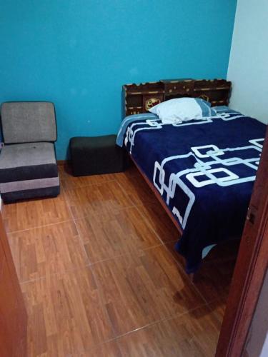 Apartamentos ARCEMIR في اياكوتشو: غرفة نوم بسرير وكرسي
