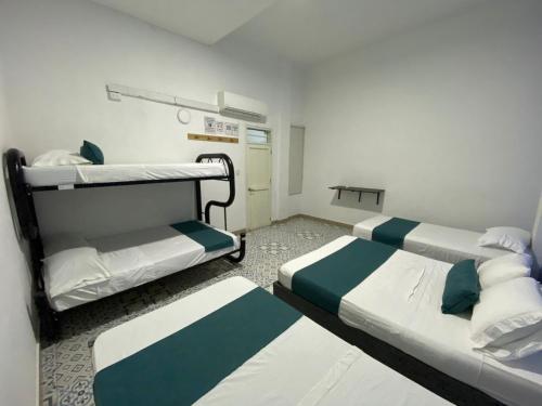 a hospital room with two beds and a table at Believer Hostel in Santa Marta