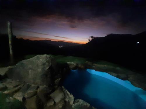a view of a pool of water at night at Cabana do Camelo in São Bento do Sapucaí