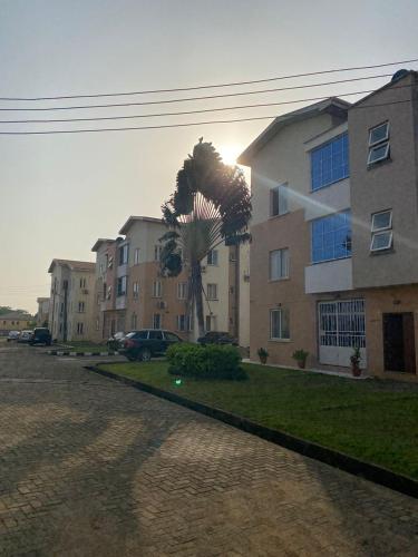 a building with a palm tree in front of it at 3 Bedroom Spacious Apartment in Okunola