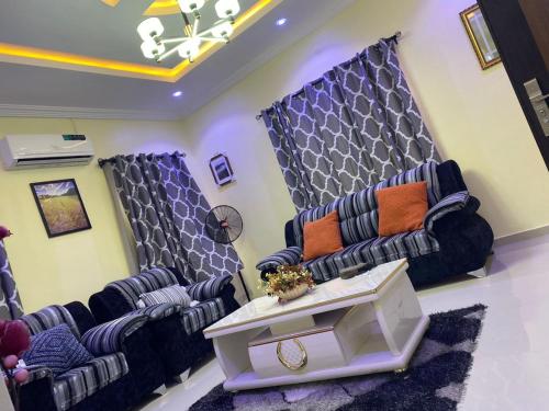 a waiting room with blue chairs and a table at 3 Bedroom Spacious Apartment in Okunola
