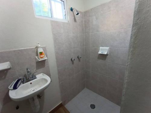 y baño blanco con lavabo y ducha. en Casa Villa (facturamos), en Los Mochis