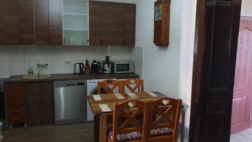 cocina con mesa, sillas y barra en Etno kuća Stara Frajla en Bački Petrovac