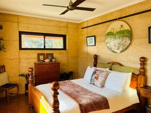 um quarto com uma cama e uma ventoinha de tecto em Rammed Earth Retreat em Wagin