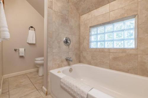 baño con bañera, aseo y ventana en Entire house 3 bedroom Twin Cities, Specious, Entire House, AC, en Saint Paul