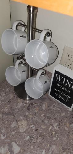 a group of coffee cups on a counter next to a sign at Luxx Guest House in Milwaukee