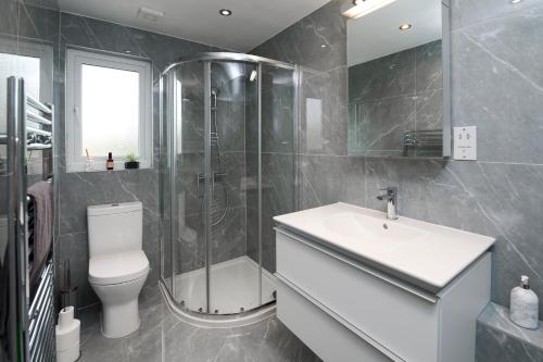 a bathroom with a shower and a toilet and a sink at Stylish 4Bed 2 Bath, NW London Large Apartment in London