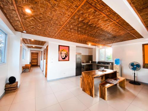 a living room with a wooden ceiling and a table at In Dai Aquasports and Beach Resort in Bantayan Island