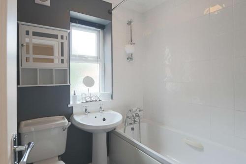 a bathroom with a sink and a toilet and a bath tub at Deluxe & Modern 2bed House in Derby