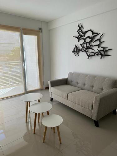 - un salon avec un canapé et deux tables dans l'établissement Departamento temporal de 1 dormitorio, à Neuquén