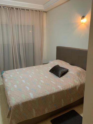 uma cama num pequeno quarto com uma janela em Ola Blanca Kiki em Sidi Rahal