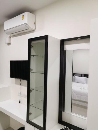 a mirror and a light in a room with a bed at NST Boutique เอ็นเอสทีบูทีค in Ban Pak Phun