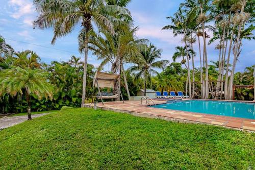 a swimming pool in a yard with palm trees at Miami Dream Home/ Pool/Jacuzzi/ Fire Pit in Miami