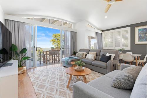 a living room with a couch and a table at Noosa Outrigger Beach Resort in Noosaville