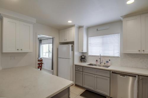 a kitchen with white cabinets and a white refrigerator at OceanCatcher - newly remodeled 3 bedroom retreat with ocean view in the heart of Mission Beach, sleeps 10 in San Diego