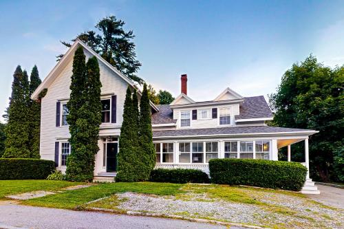 a white house with trees in front of it at Norwood Curtis House in Camden