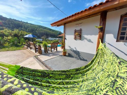 uma casa com uma rede verde fora dela em Pousada Pé na Montanha em Socorro