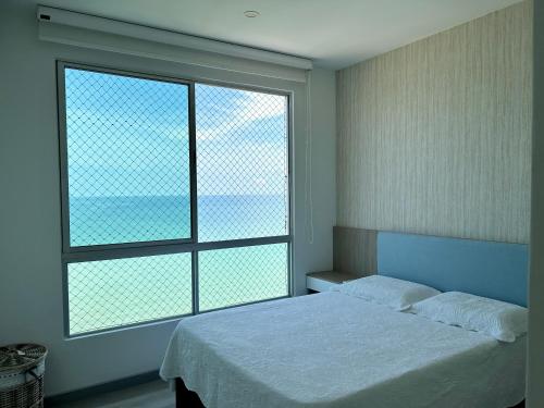 ein Schlafzimmer mit einem Bett und zwei großen Fenstern in der Unterkunft Oceanview Apartment 3 bedrooms in Coveñas