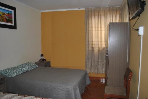 1 dormitorio con cama y ventana en Casa Familiar, en Ayacucho