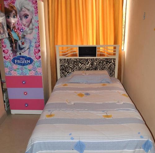 1 dormitorio con 1 cama y una pintura de Barbie en Casa Familiar, en Ayacucho