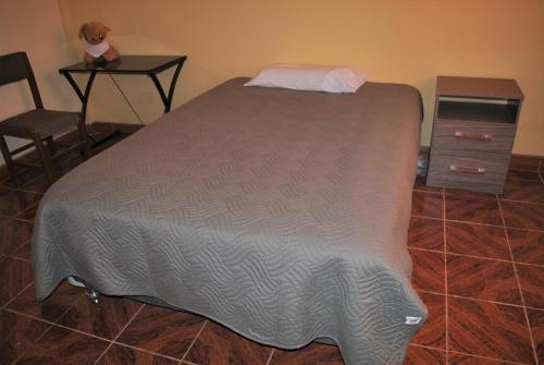 1 dormitorio con 1 cama, 1 mesa y 1 silla en Casa Familiar, en Ayacucho