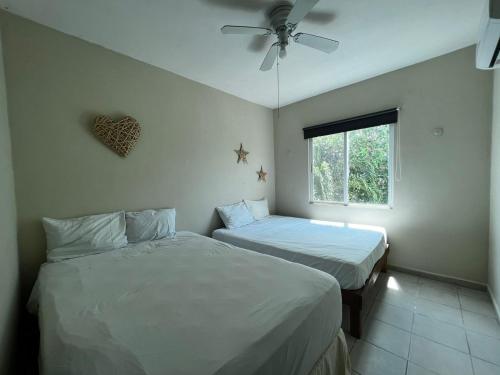 um quarto com duas camas e uma janela em Casa con alberca y jardín en Cancún em Cancún