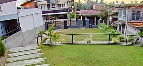 a view of a house with a fence and a yard at Pastora House Luxe Staycation Bauan Batangas in Bauan
