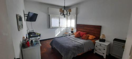 a bedroom with a bed and a window and a television at Chalet Playa Grande in Mar del Plata