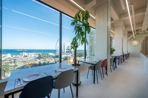a dining room with tables and chairs and a large window at Sokcho Good Morning Hotel and Resort in Sokcho