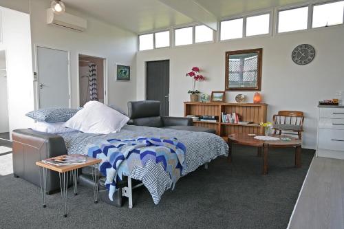 a bedroom with a bed and a desk and a chair at Bella Park - New Plymouth Holiday Studio in New Plymouth