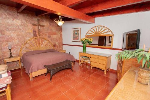 a bedroom with a bed and a table and a desk at ¡Increíble casa en Avándaro para 10 personas! in Valle de Bravo