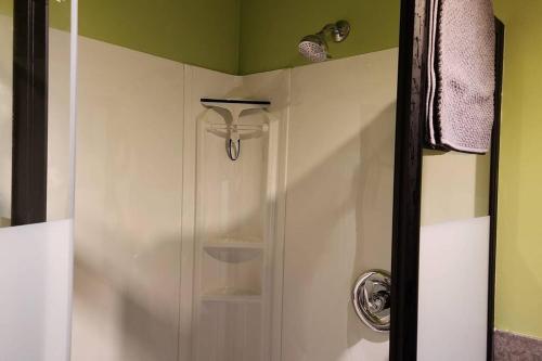a shower in a bathroom with a glass door at cozy apartment near the ocean in Guysborough