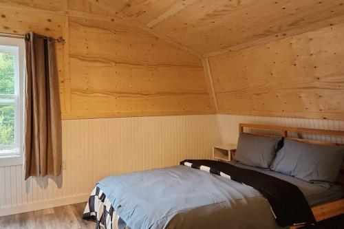 ein Schlafzimmer mit einem Bett in einem Blockhaus in der Unterkunft cozy apartment near the ocean in Guysborough