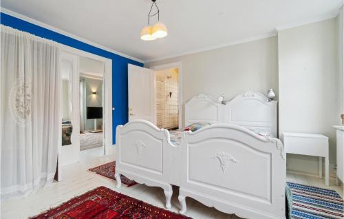 - une chambre avec 2 lits blancs et un mur bleu dans l'établissement Beautiful Apartment In Svaneke With Wifi And 2 Bedrooms, à Svaneke