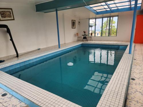 a large swimming pool with a blue tiled floor and a table at Home Away from Home in Suva