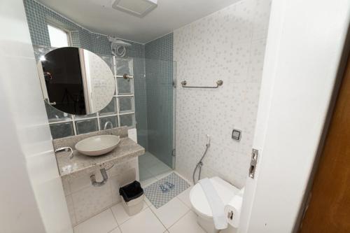 a bathroom with a toilet and a sink and a mirror at Apt por temporada - Ponta Verde - De frente ao Caminho de Moises - 02 quartos in Maceió