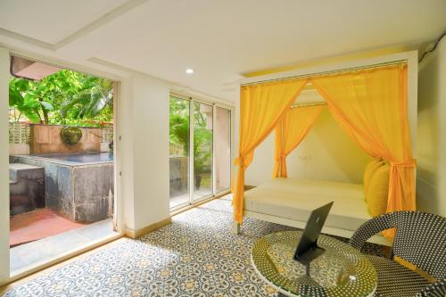 Zimmer mit einem Bett, einem Tisch und einem Fenster in der Unterkunft Luxury 4BHK Villa with Private Pool Near Candolim in Marmagao