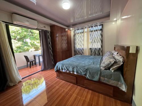1 dormitorio con cama y ventana grande en Laguindingan Town House, 