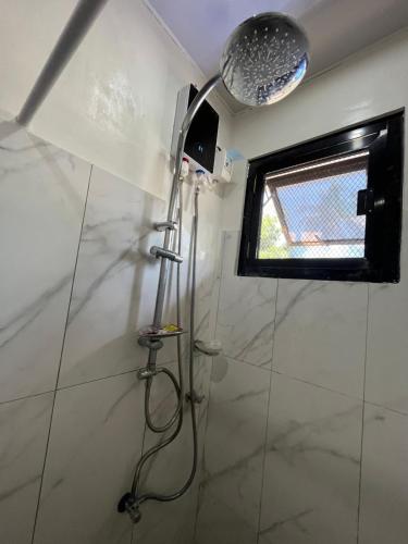 um chuveiro na casa de banho com uma janela em Laguindingan Town House 