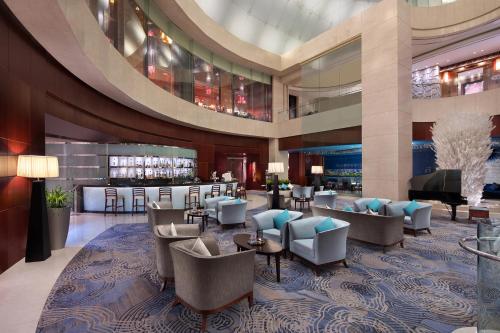 a lobby of a hotel with chairs and a bar at Beijing Marriott Hotel Northeast in Beijing
