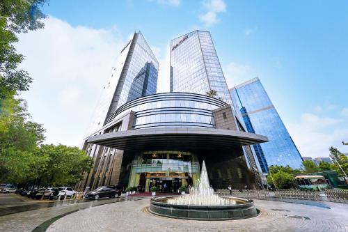 een fontein voor een gebouw met hoge gebouwen bij Beijing Marriott Hotel Northeast in Beijing