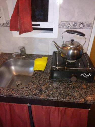 a kitchen counter with a sink and a pot on a stove at Aparts Altos del Centro in Merlo