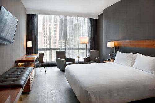 AC Hotel by Marriott Panama City في مدينة باناما: غرفة فندقية بسرير ونافذة كبيرة