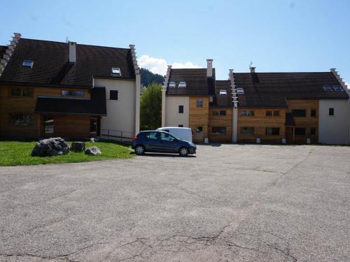 a car parked in a parking lot in front of some buildings at Charmant appartement avec balcon exposé sud, à 450m du centre et des pistes de fond – Autrans. - FR-1-737-56 in Autrans
