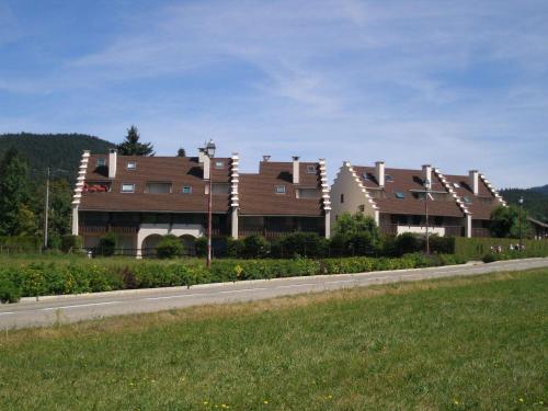 a row of houses on the side of a road at Charmant appartement avec balcon exposé sud, à 450m du centre et des pistes de fond – Autrans. - FR-1-737-56 in Autrans