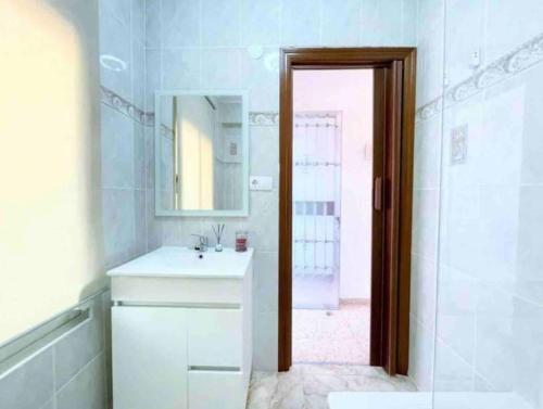 Un baño blanco con lavabo y espejo. en Studio Almenara Beach, en Barrio-Mar