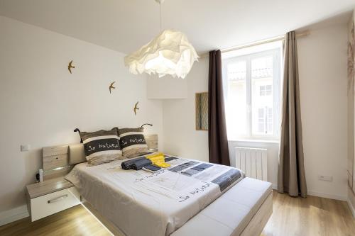 1 dormitorio con cama y ventana grande en L'Emeraude - 1 à 4P - Wifi Fibre - Parking Gratuit, en Pont-d'Ain
