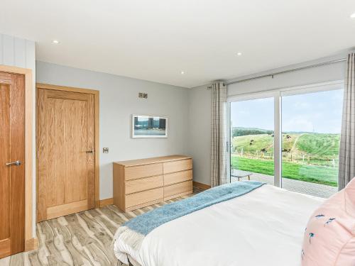 a bedroom with a bed and a large window at High Tide - Uk44283 in Gatehouse of Fleet